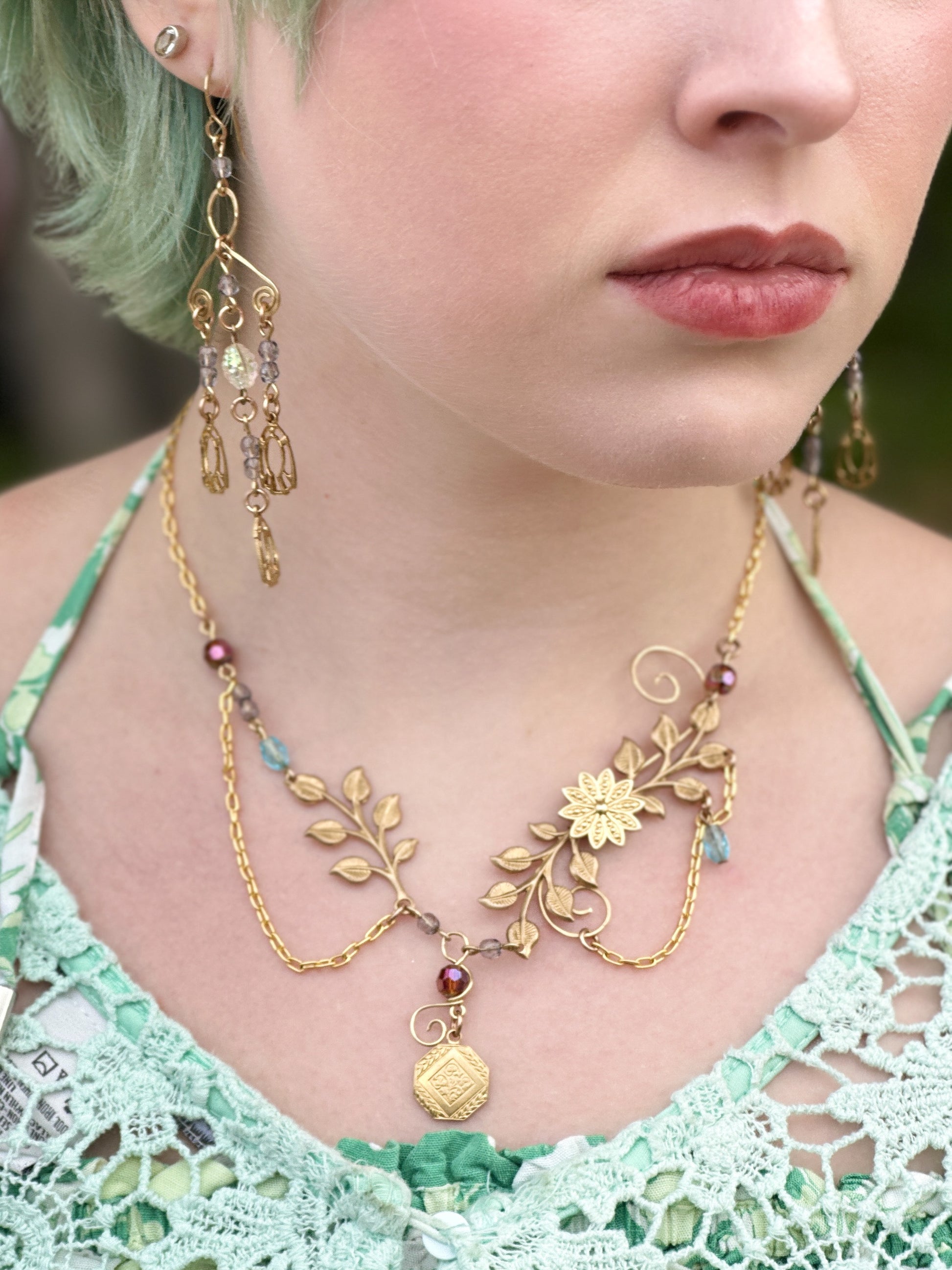 Woman wearing gold leaf necklace and earrings (9C13FB28)
