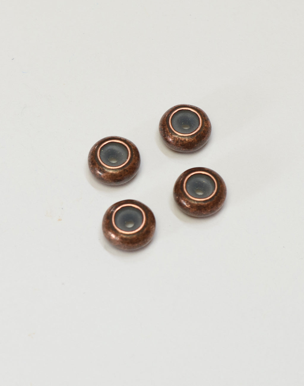 Four copper beads with dark center