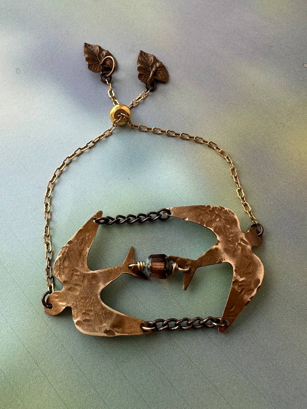 Bronze bird bracelet with leaf accents