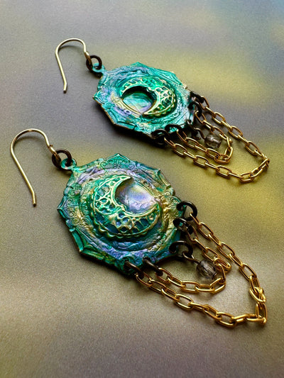 Green and gold crescent moon earrings with chains.