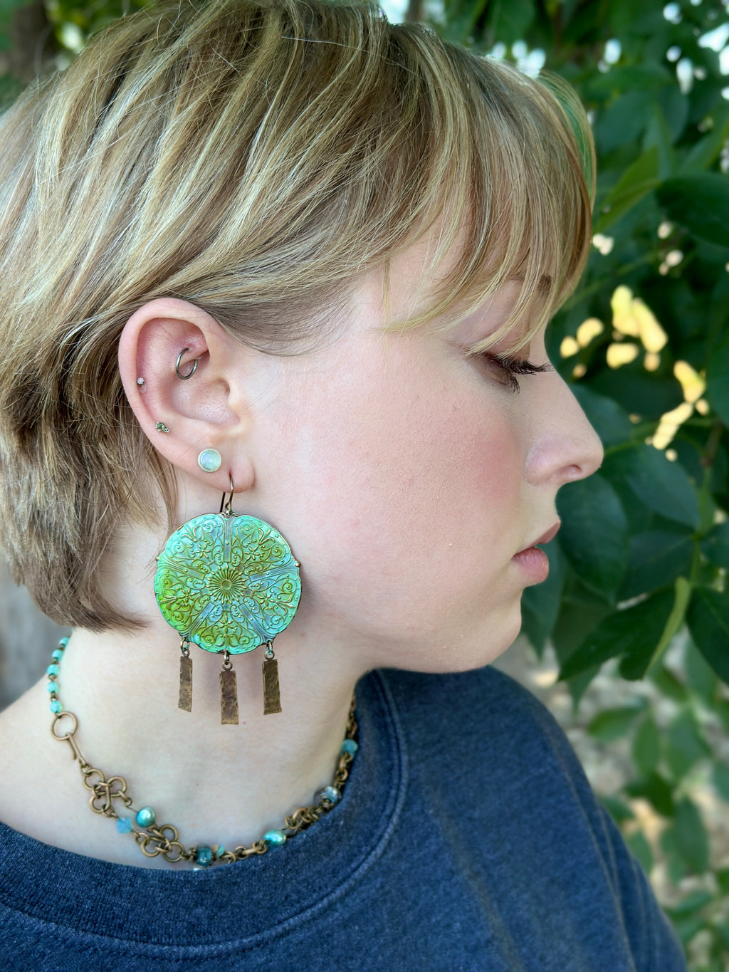 Woman wearing large green earrings