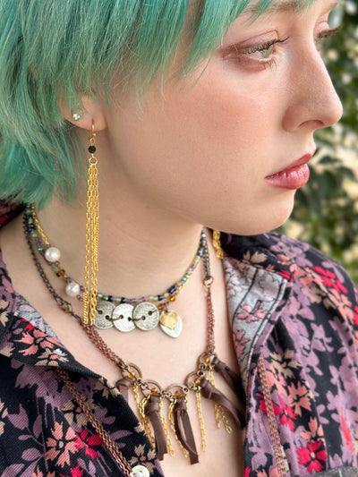 Woman with green hair and layered jewelry