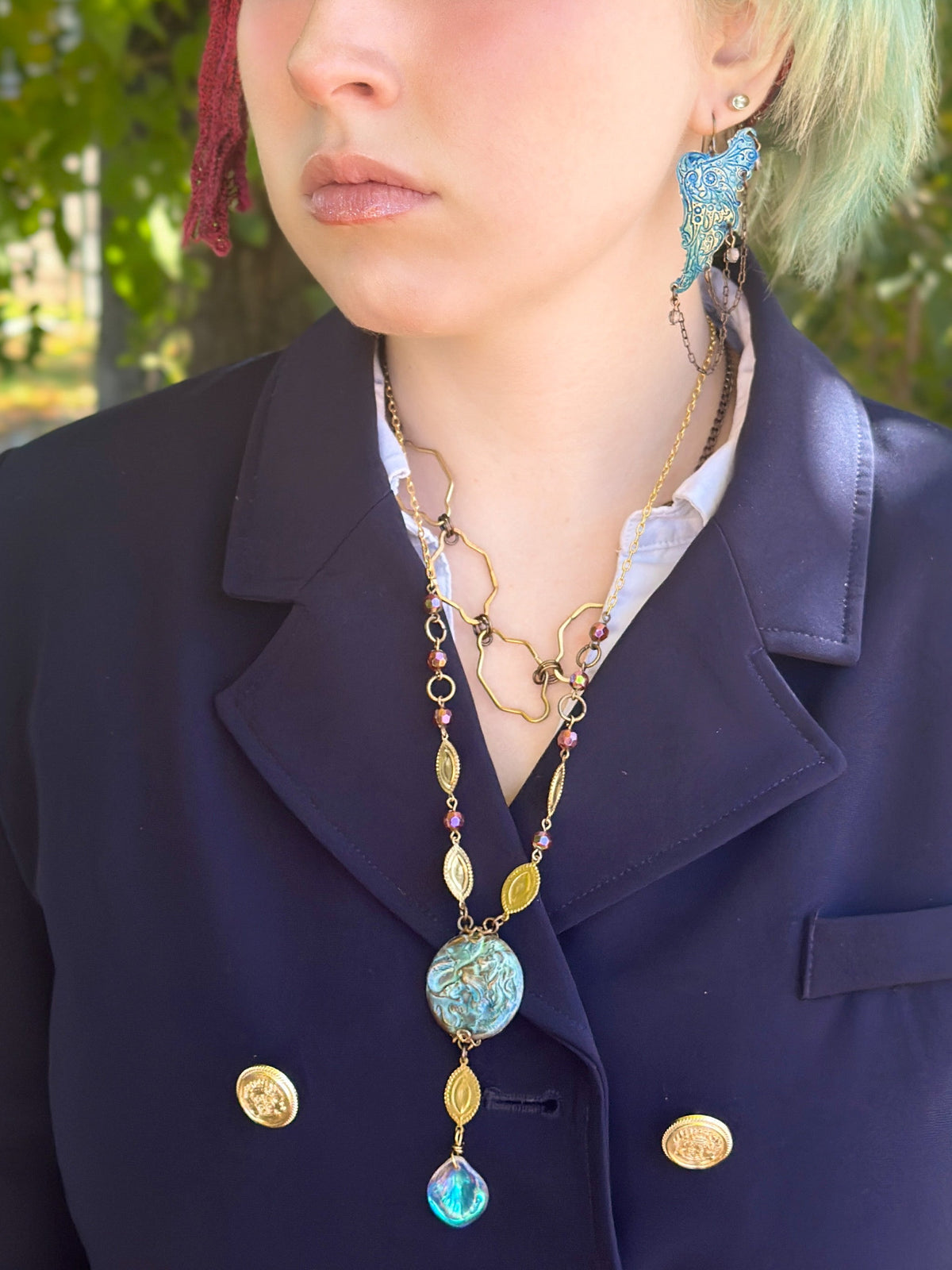 Woman wearing jewelry and a blazer.
