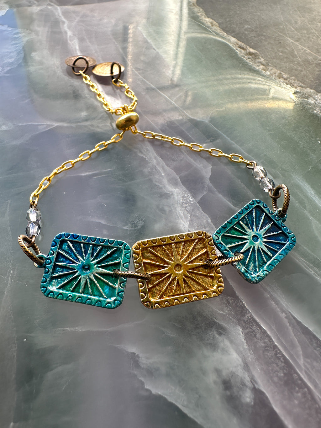 Gold and turquoise bracelet with square charms.