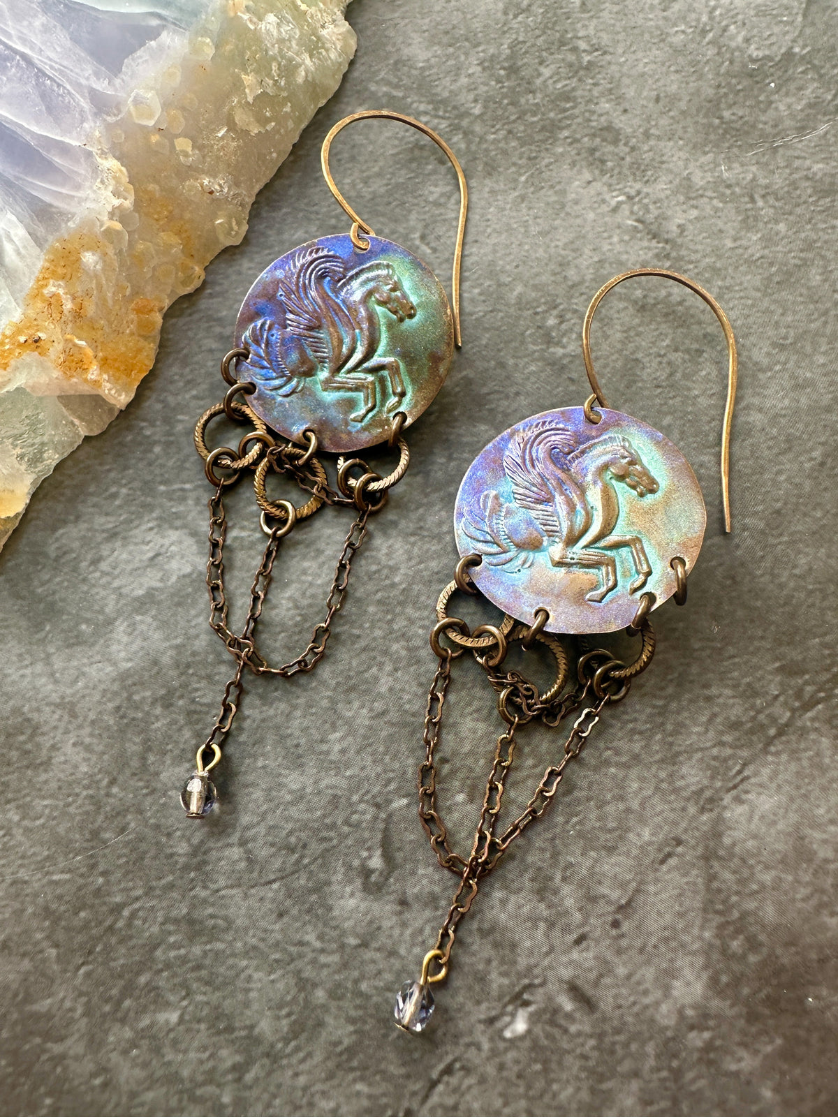 Pegasus earrings with chain dangles.