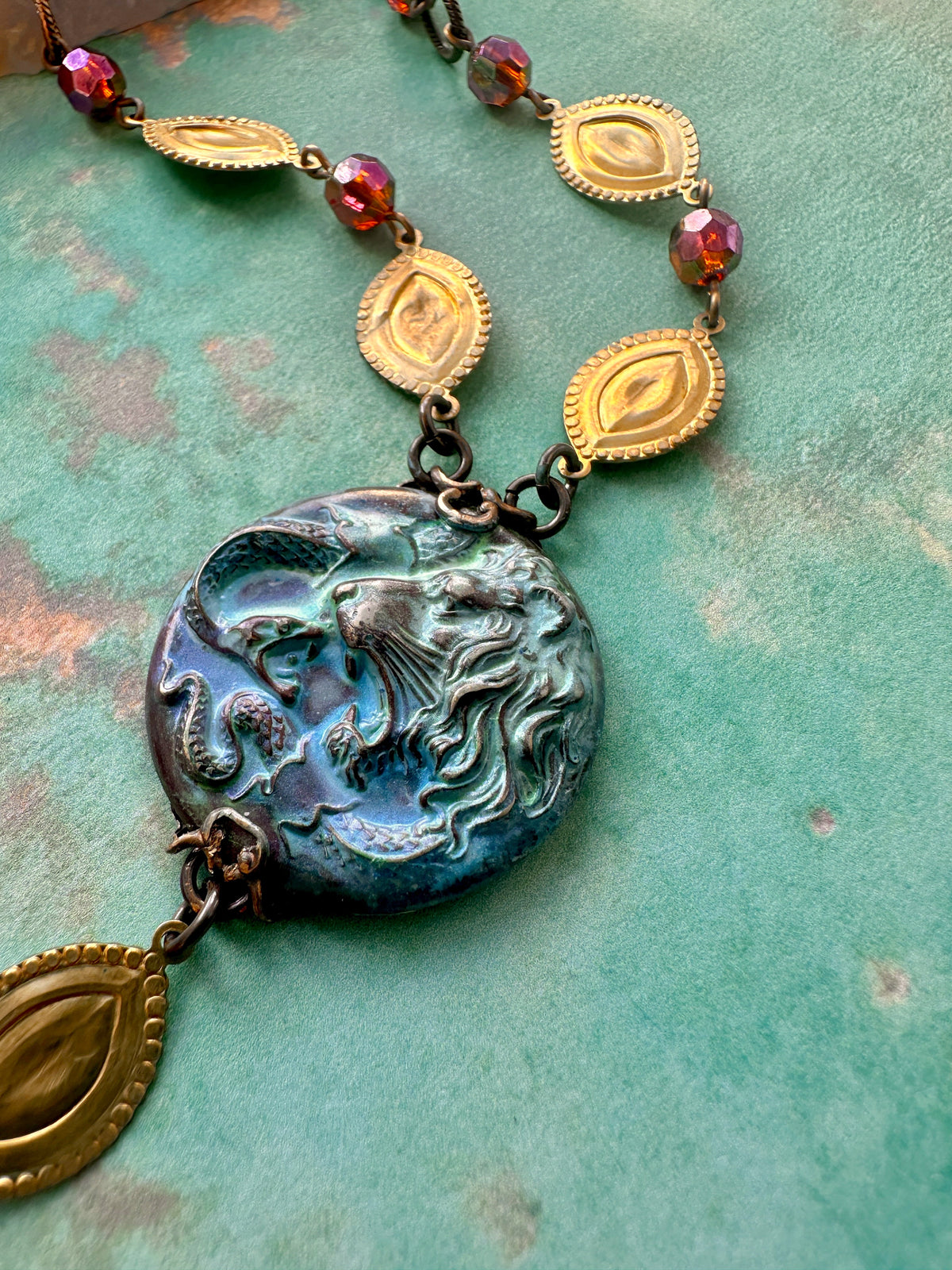 Necklace with lion pendant and decorative chain.