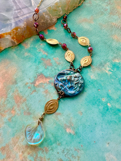Jeweled necklace with blue and gold pendant.