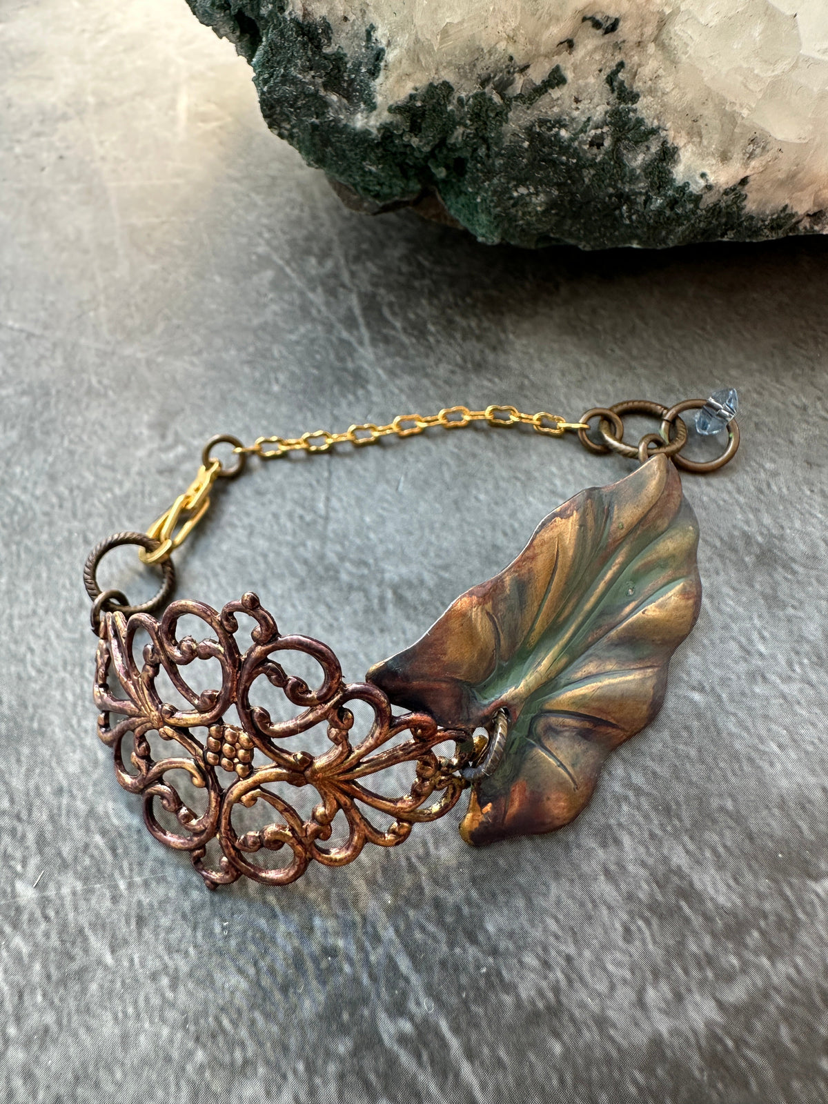 Copper bracelet with leaf and filigree details.
