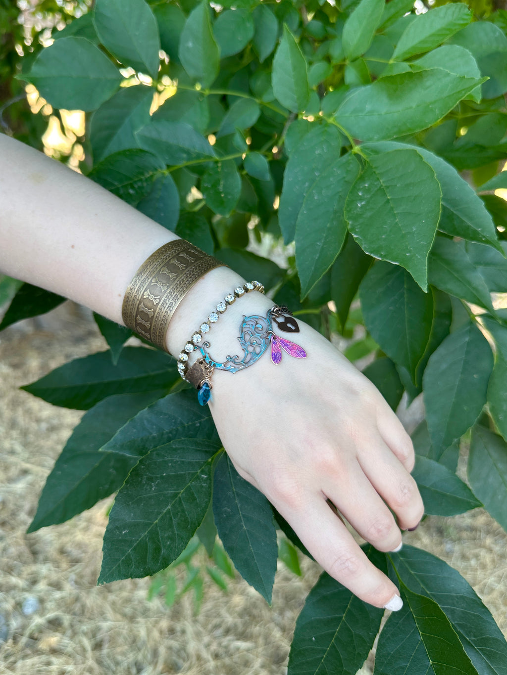 Arm with bracelets and green leaves.