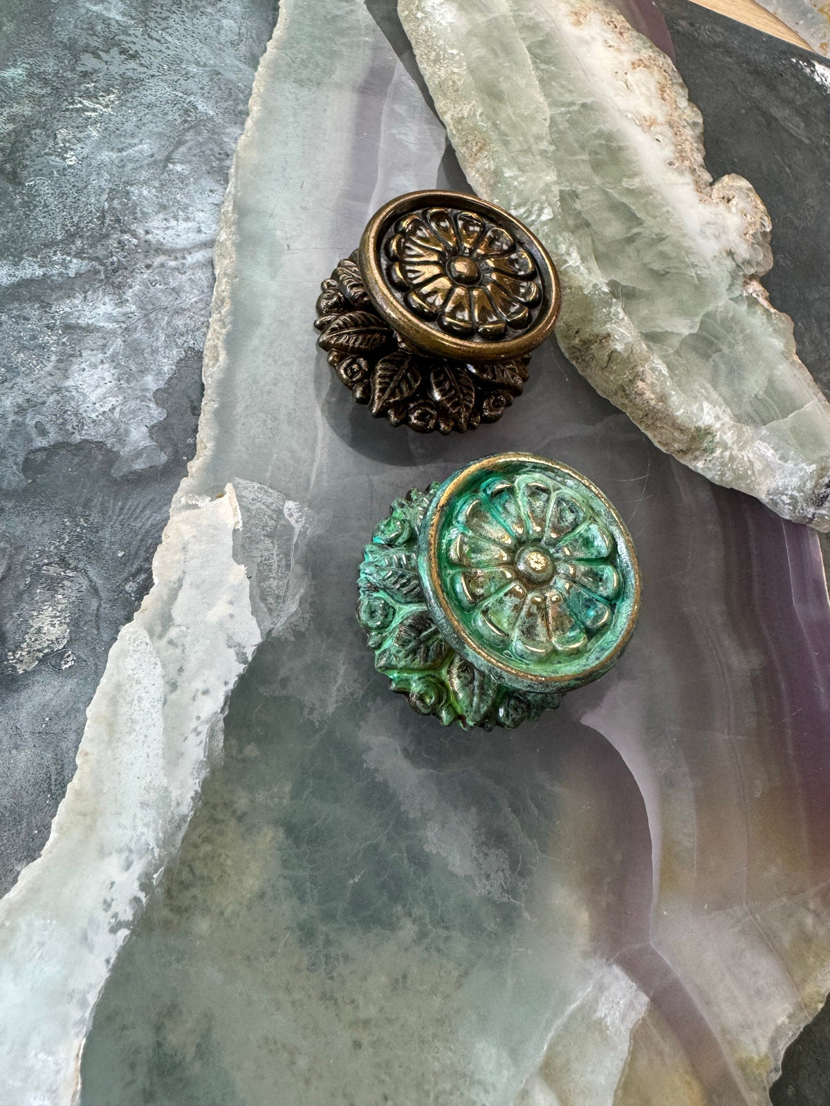 Two decorative door knobs on stone.