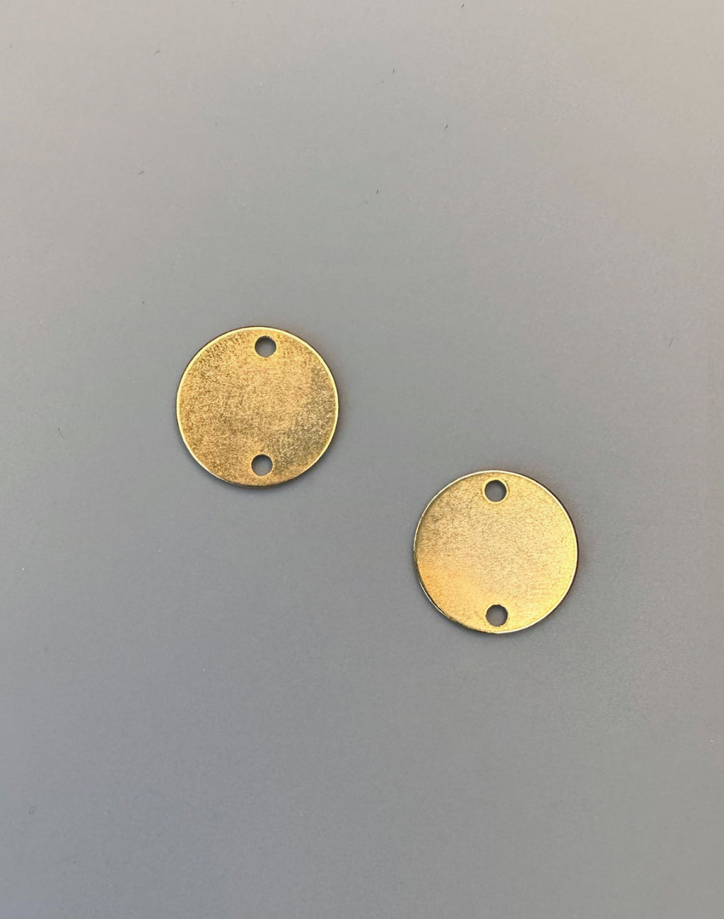Two gold round metal connector pieces