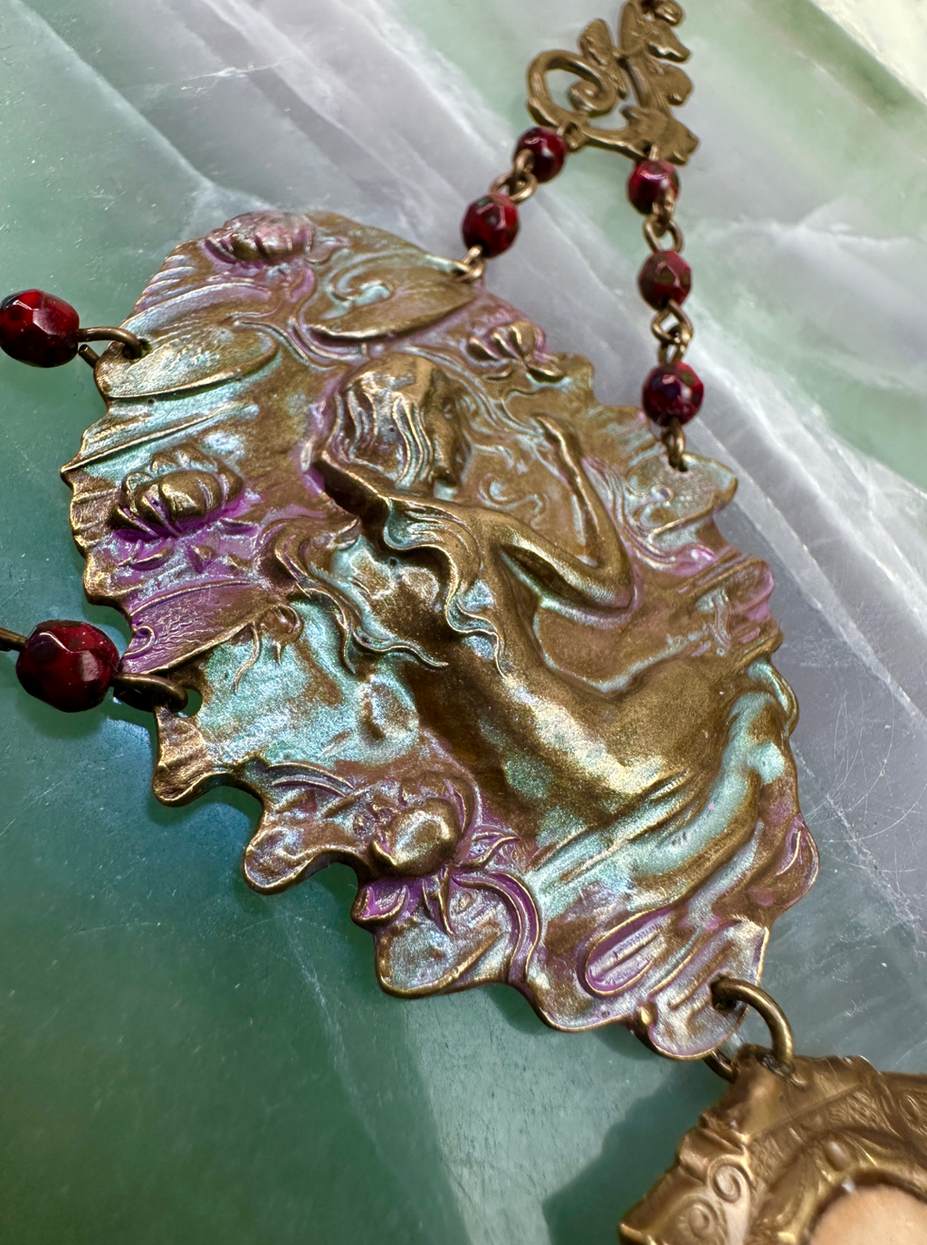 Ornate brass pendant necklace with red beads