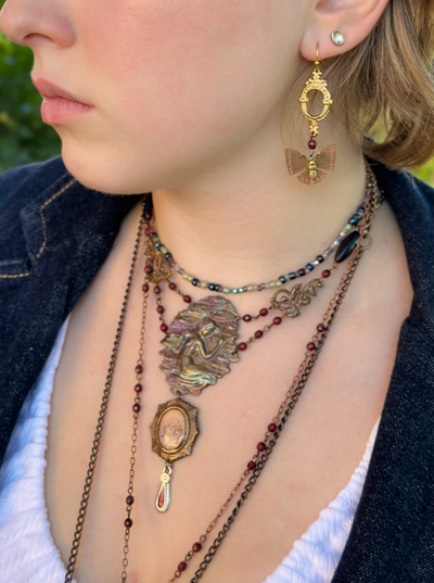 Woman wearing vintage jewelry, including necklace and earrings.