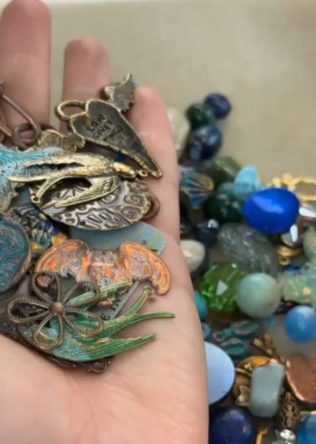 Hand holding vintage metal charms and beads - oak2