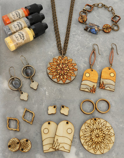 Jewelry and stain bottles, including a wood mandala pendant.