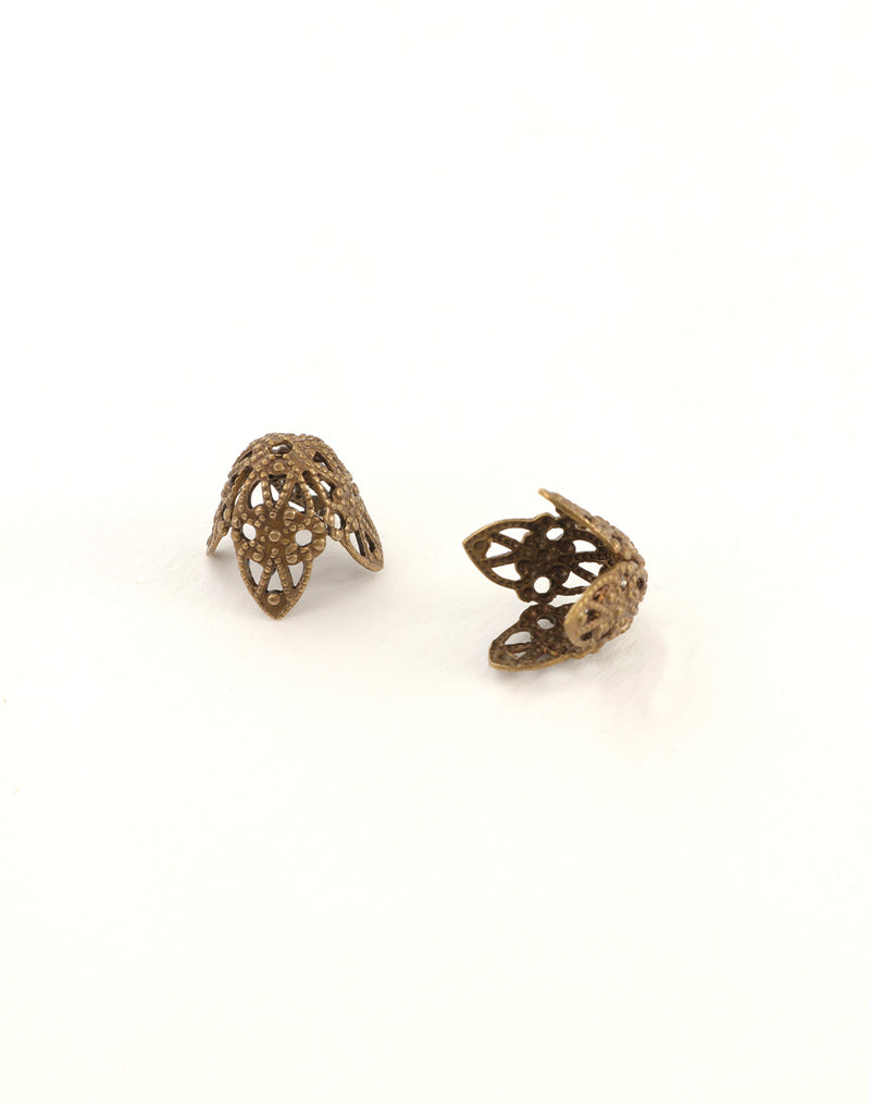 Two ornate bronze bead caps on white background.