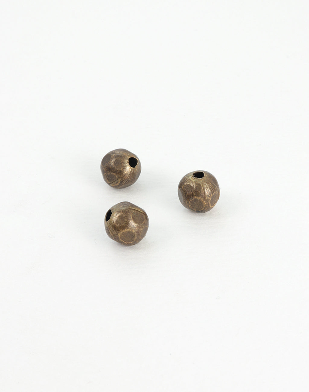Three textured brown beads on white background.