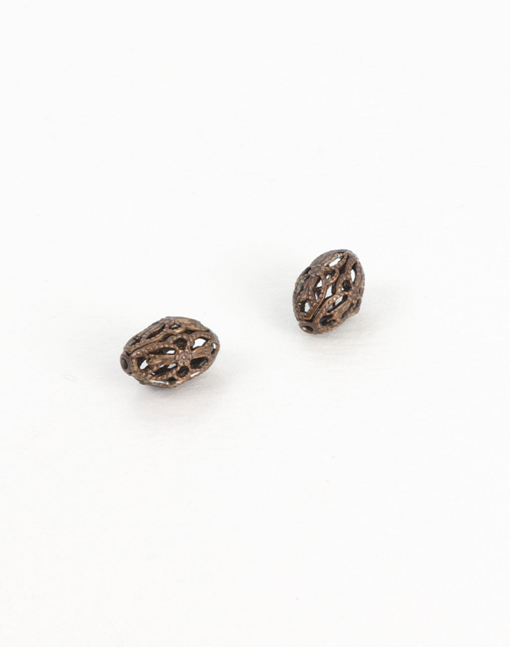 Two antique filigree beads on white background.