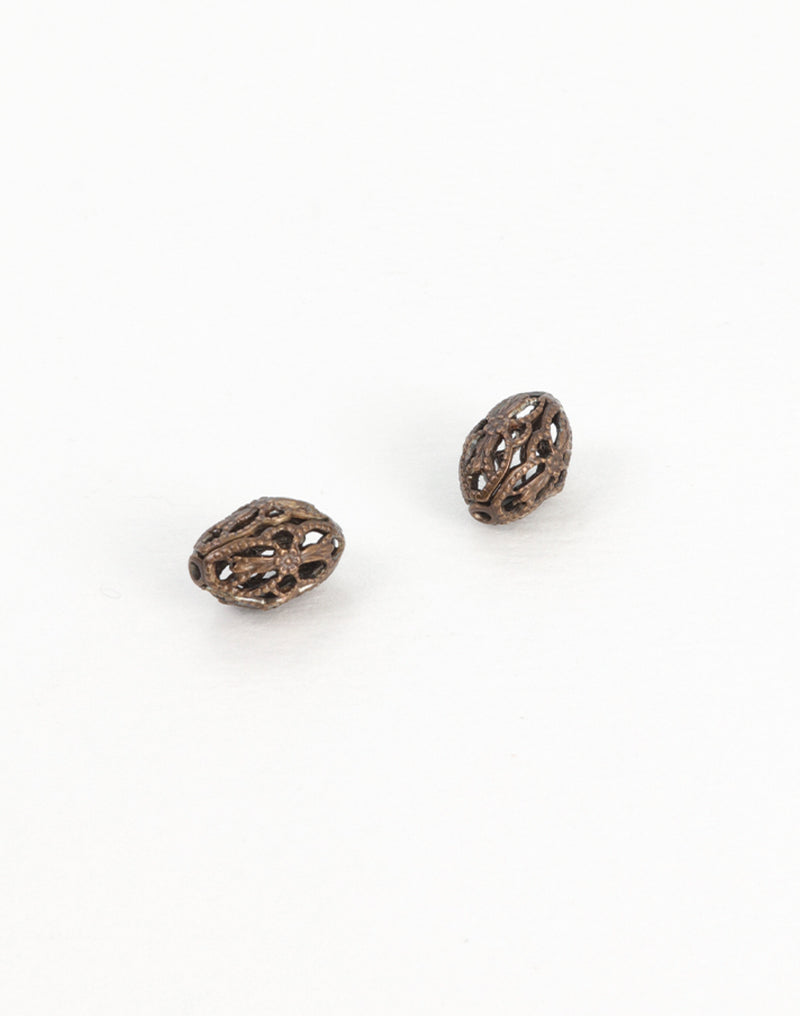 Two antique filigree beads on white background.