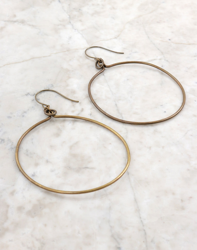 Gold hoop earrings on white marble