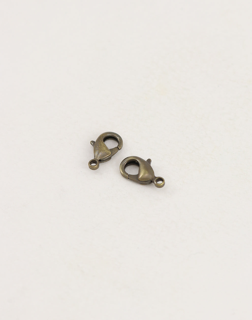 Two bronze lobster clasps on white background