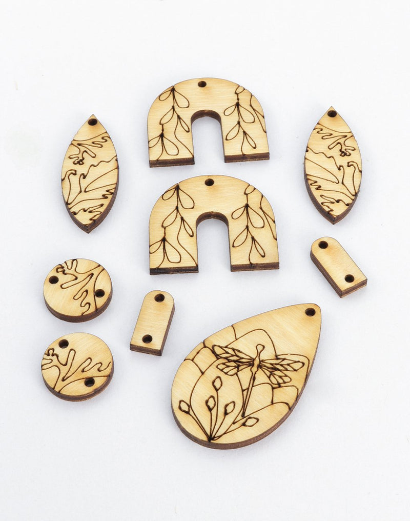 Laser cut wooden jewelry pieces with botanical designs
