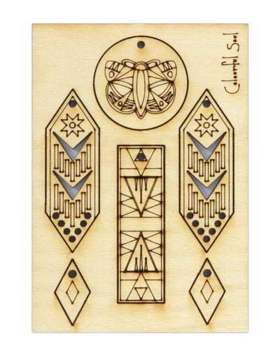Laser-cut wooden art with butterfly and geometric designs.