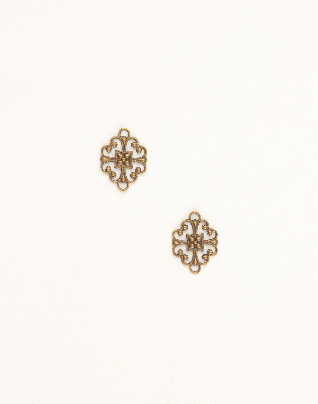 Two ornate brass filigree charms