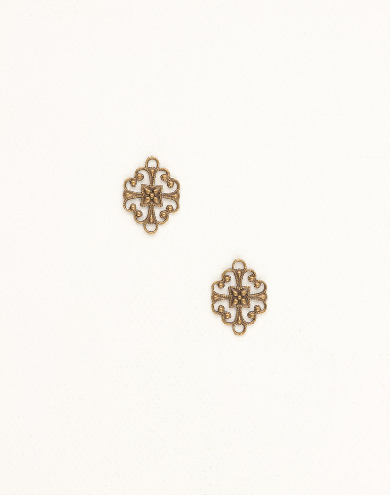 Two ornate brass filigree charms