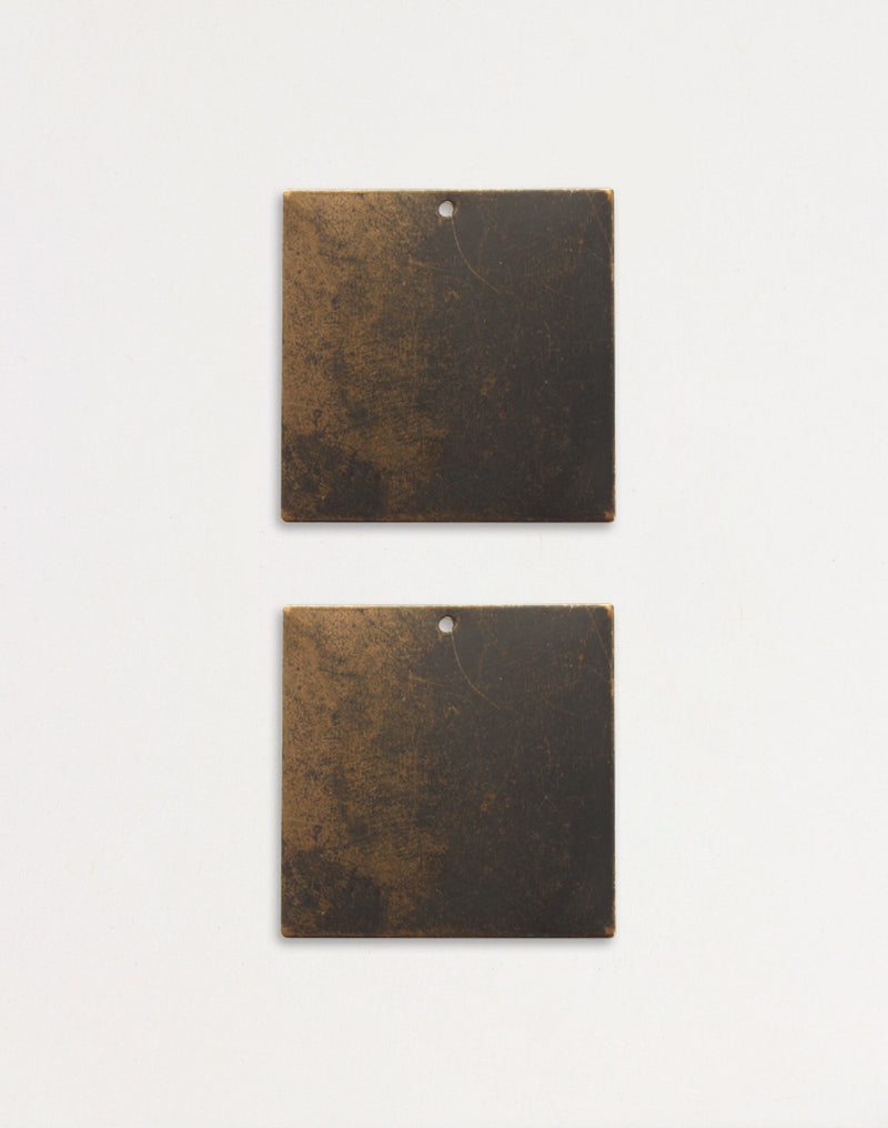 Two square metal tiles with aged finish