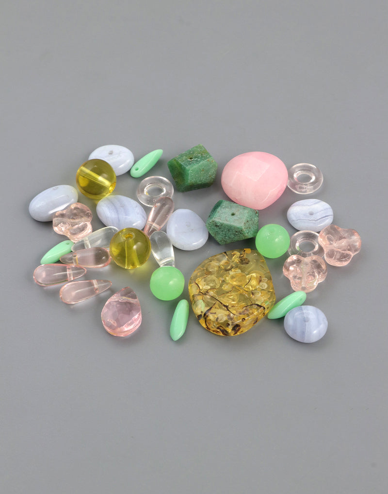 Assorted colorful beads and gemstones on gray background