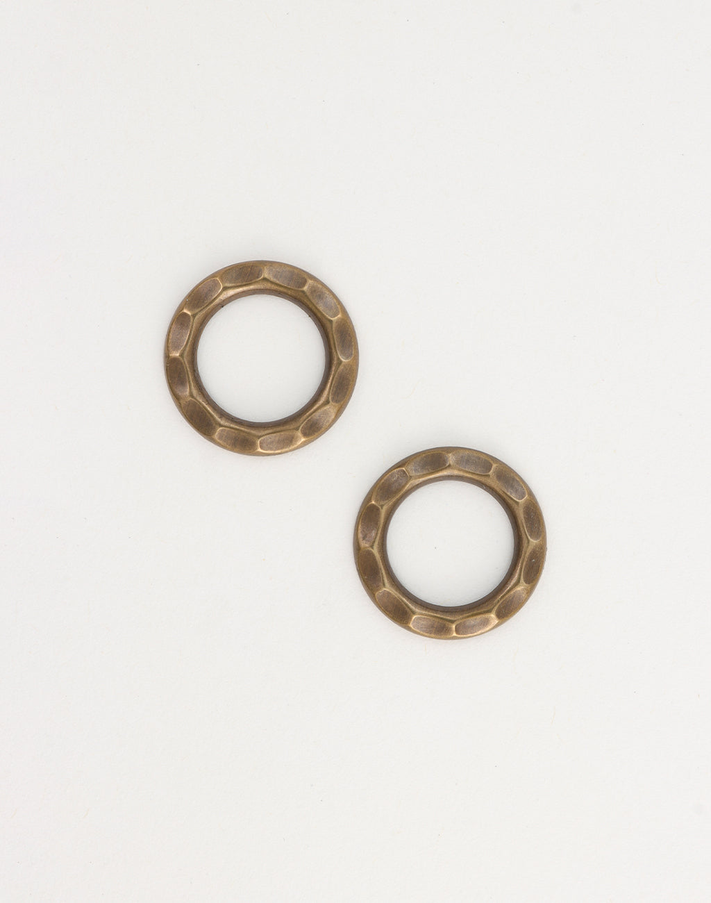 Two hammered metal rings on white